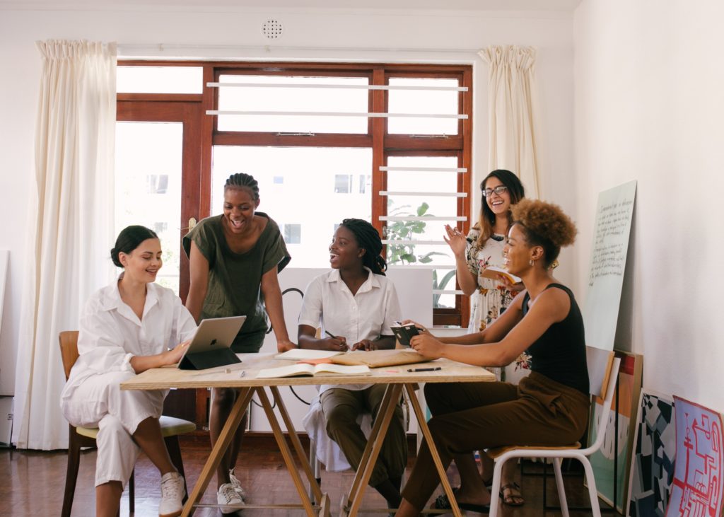 A happy, productive workplace with five women enjoying their work.